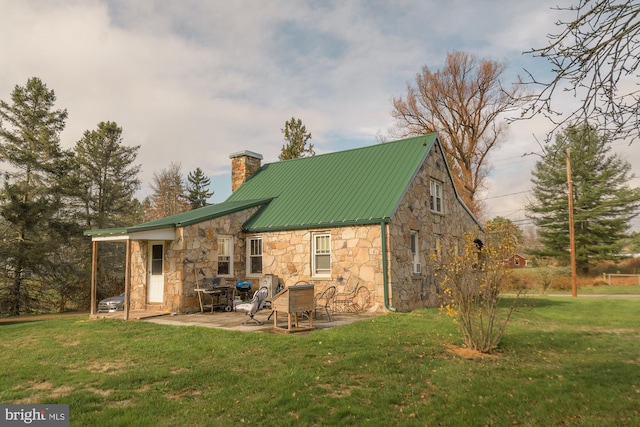 back of property featuring a lawn and a patio