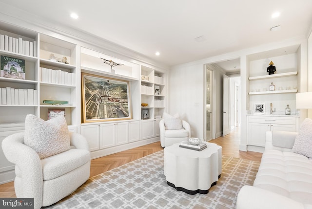 living room featuring crown molding, built in features, and light parquet floors