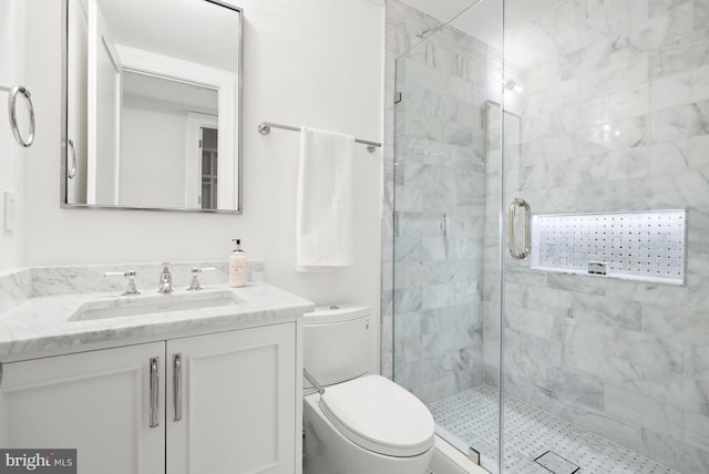 bathroom featuring vanity, toilet, and a shower with shower door