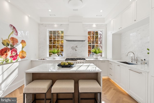 kitchen featuring backsplash, white cabinetry, plenty of natural light, and sink