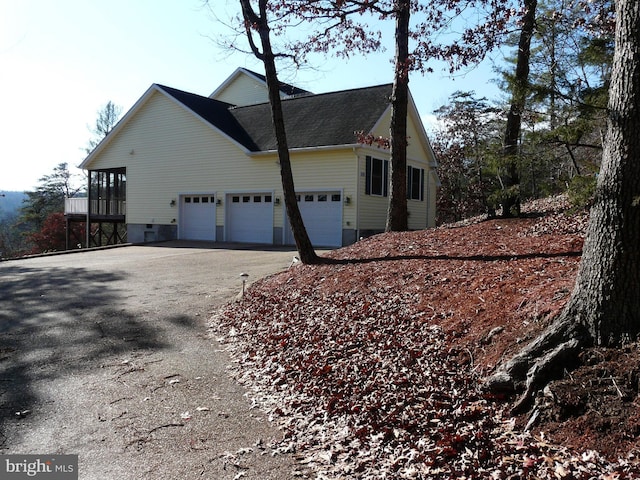 view of side of home featuring a garage and a sunroom