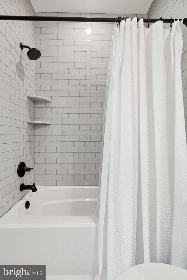 bathroom with toilet and shower / bathtub combination with curtain