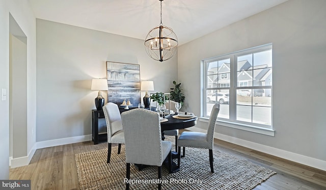 dining area with hardwood / wood-style floors and an inviting chandelier