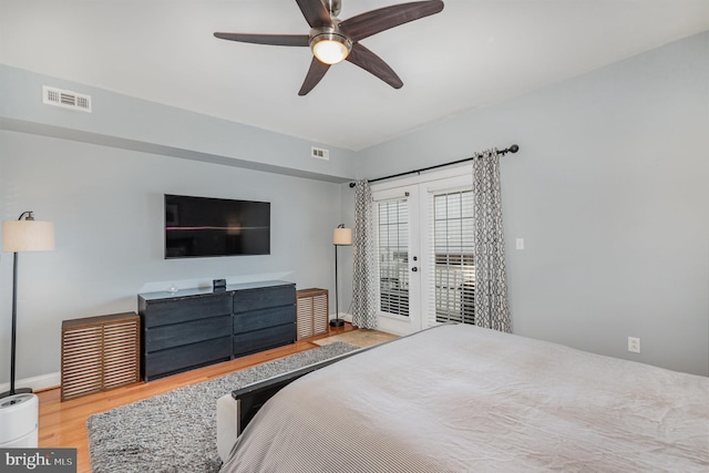 bedroom featuring ceiling fan, light hardwood / wood-style floors, access to exterior, and french doors