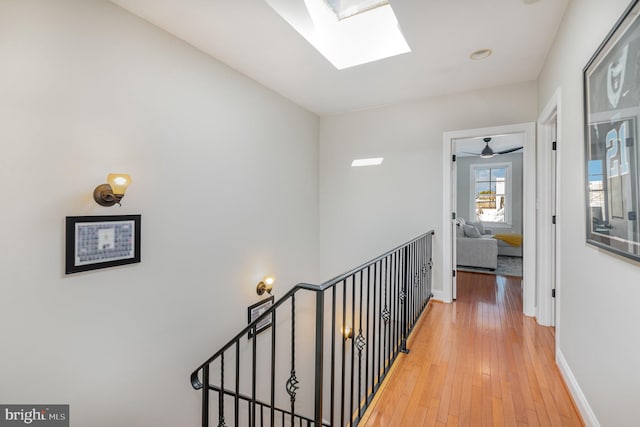 corridor featuring hardwood / wood-style floors and a skylight