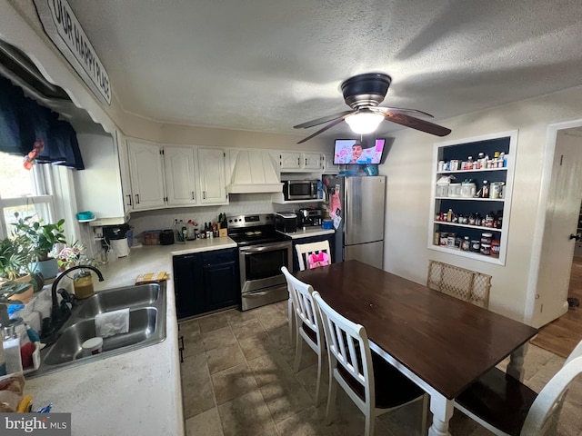 kitchen featuring white cabinetry, sink, appliances with stainless steel finishes, ceiling fan, and a textured ceiling