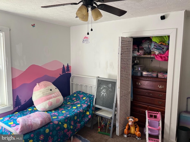 bedroom with a textured ceiling, carpet flooring, and ceiling fan