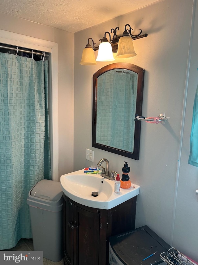 bathroom with vanity, toilet, and a textured ceiling