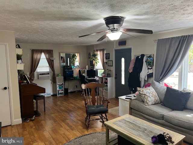 living room with ceiling fan, cooling unit, a textured ceiling, and dark hardwood / wood-style floors