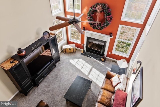 living room with a high ceiling, carpet floors, a wealth of natural light, and ceiling fan