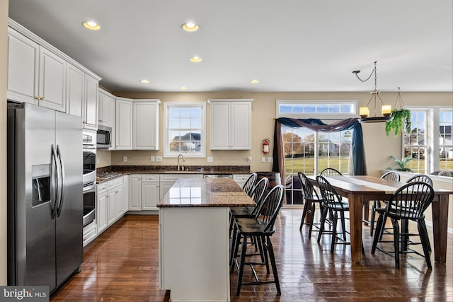 kitchen featuring a healthy amount of sunlight, dark wood-type flooring, white cabinets, and stainless steel appliances