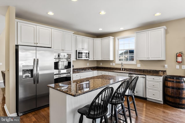 kitchen featuring dark hardwood / wood-style floors, a center island, white cabinetry, and stainless steel appliances