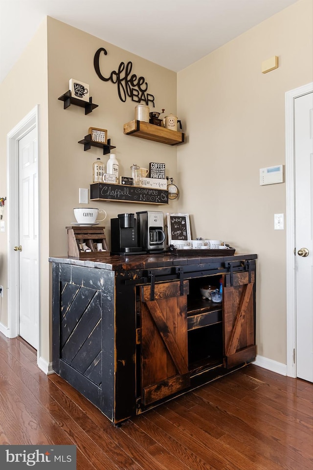 bar with dark hardwood / wood-style flooring