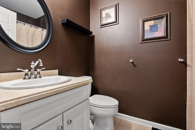 bathroom with tile patterned flooring, vanity, and toilet