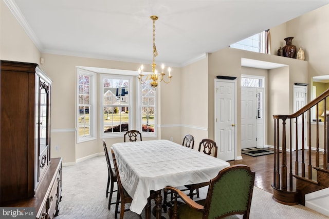 dining space with hardwood / wood-style flooring, crown molding, and a chandelier