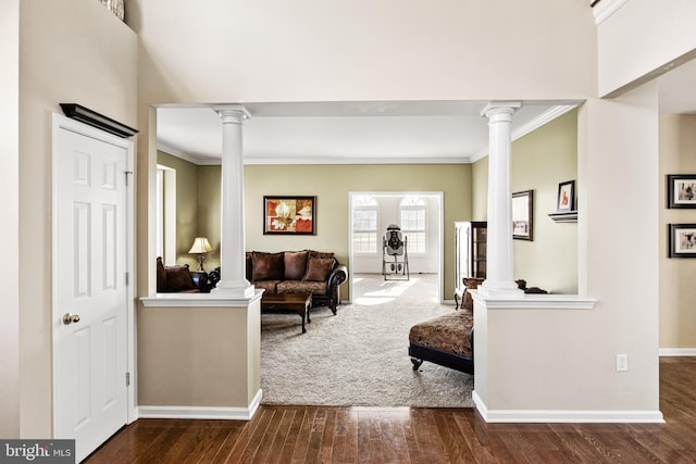 living room featuring hardwood / wood-style flooring, ornamental molding, and decorative columns