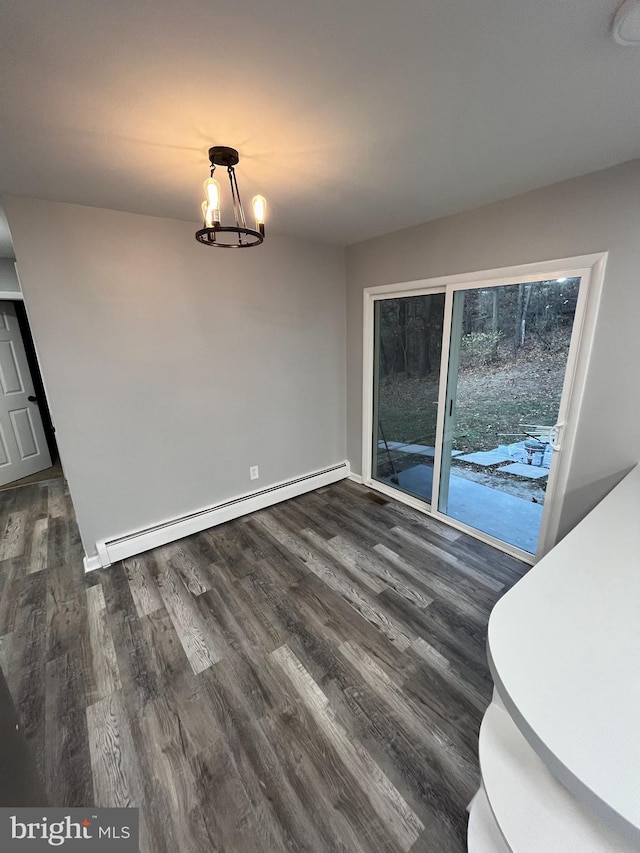 unfurnished dining area featuring dark wood-type flooring, a baseboard radiator, and an inviting chandelier