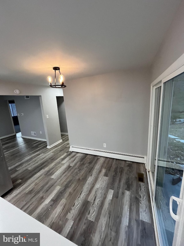 empty room featuring dark hardwood / wood-style flooring and a baseboard radiator