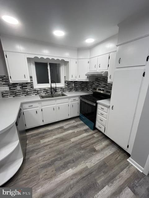 kitchen with tasteful backsplash, white cabinetry, dark hardwood / wood-style floors, sink, and electric range