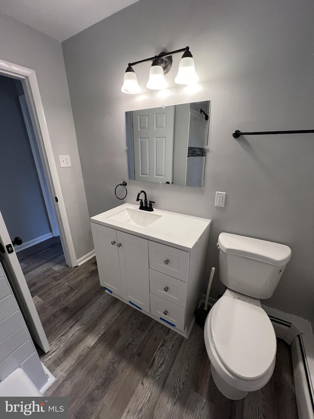 bathroom with toilet, vanity, and hardwood / wood-style flooring