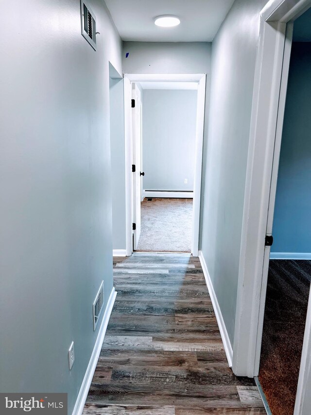 hall featuring dark wood-type flooring and baseboard heating