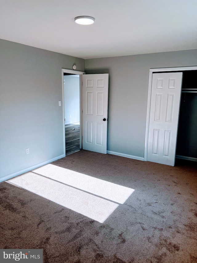 unfurnished bedroom with a closet and carpet floors