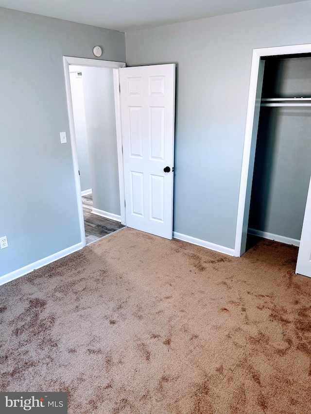 unfurnished bedroom featuring carpet flooring and a closet