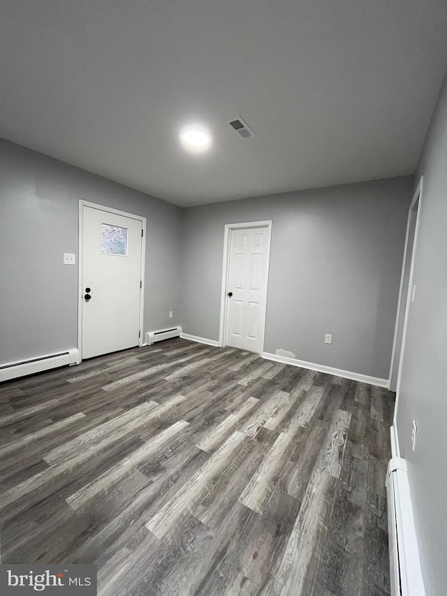 interior space with baseboard heating and dark wood-type flooring