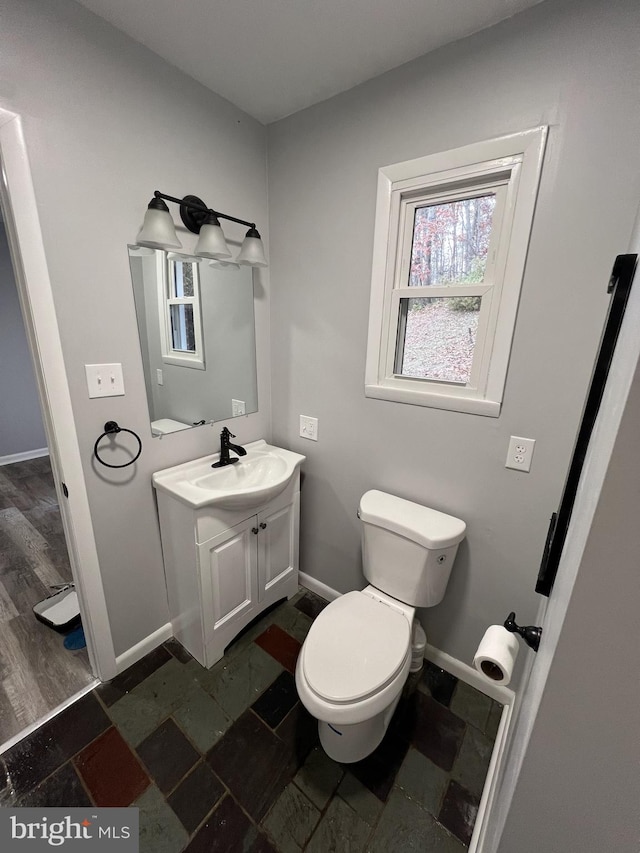 bathroom featuring toilet, vanity, and hardwood / wood-style flooring