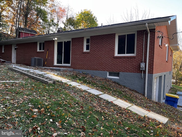 rear view of house featuring central AC unit and a garage