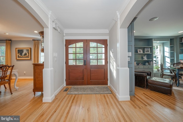 entrance foyer featuring french doors, light hardwood / wood-style floors, and a healthy amount of sunlight