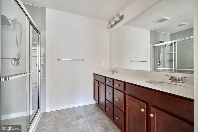 bathroom with vanity, an enclosed shower, and tile patterned flooring