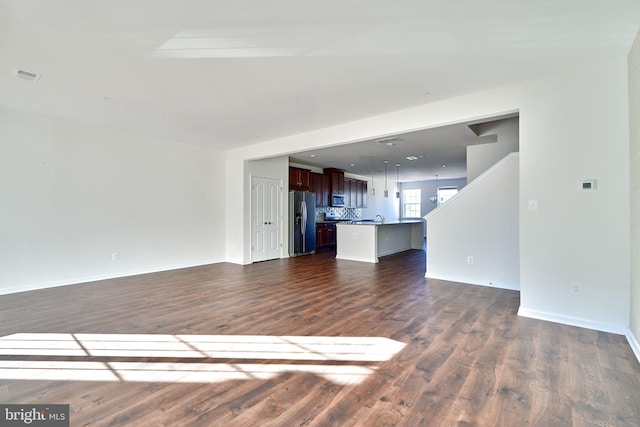 unfurnished living room featuring dark hardwood / wood-style floors and sink