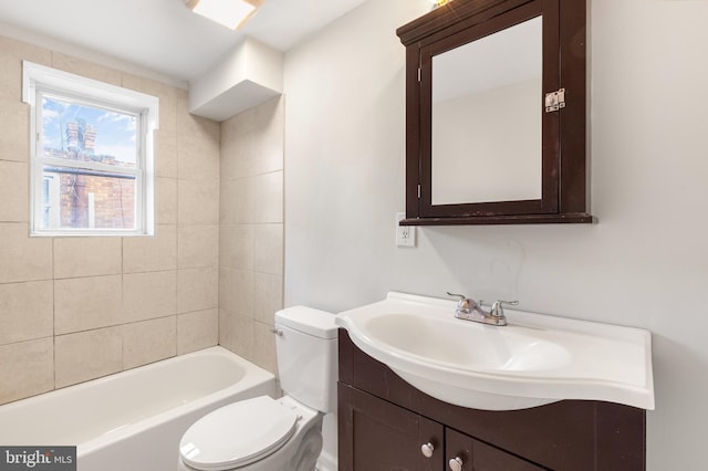 full bathroom with toilet, vanity, and tiled shower / bath