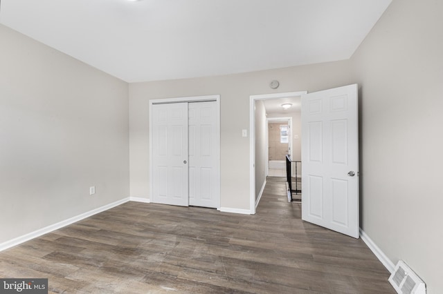 unfurnished bedroom featuring dark hardwood / wood-style floors and a closet