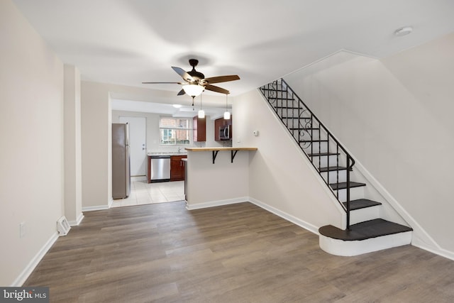 staircase with hardwood / wood-style floors and ceiling fan