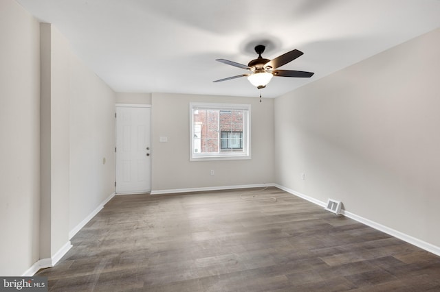 spare room featuring dark wood-type flooring and ceiling fan