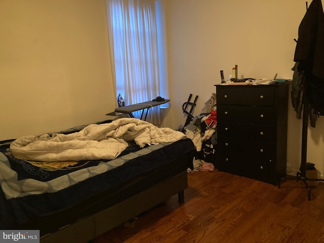 bedroom with dark wood-type flooring