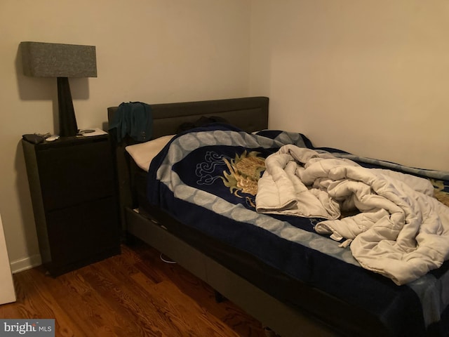 bedroom with dark hardwood / wood-style flooring