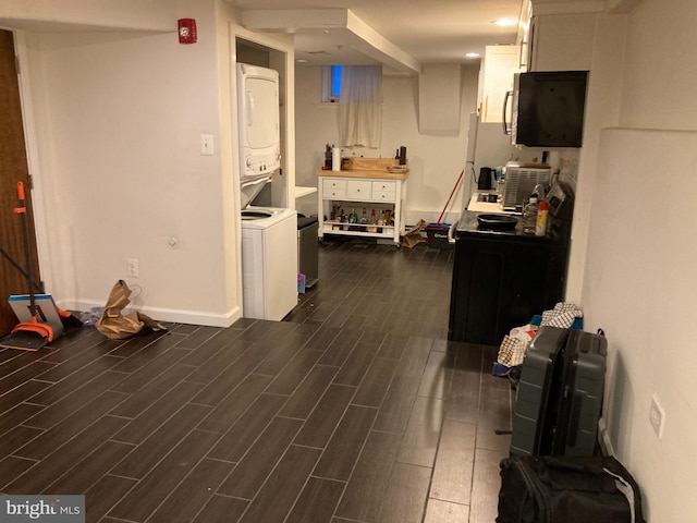 interior space with dark wood-type flooring and stacked washer and clothes dryer