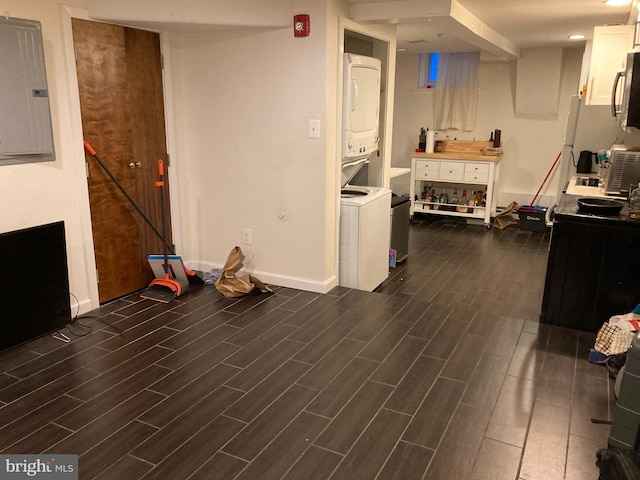 interior space featuring electric panel, stacked washer and dryer, and dark wood-type flooring