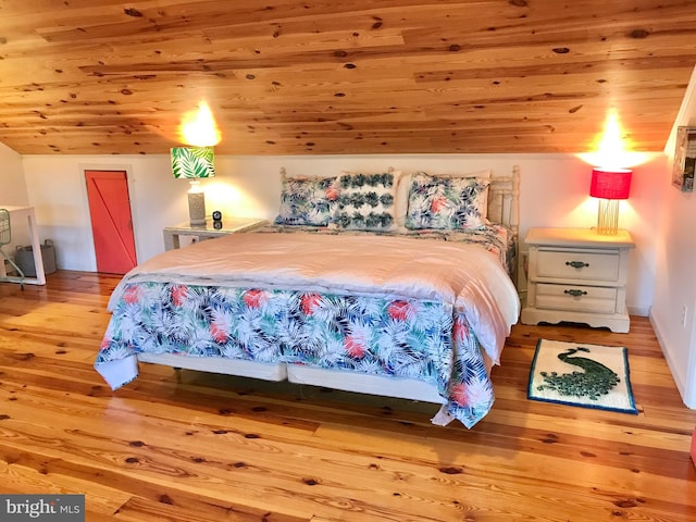 bedroom with light hardwood / wood-style floors, vaulted ceiling, and wood ceiling