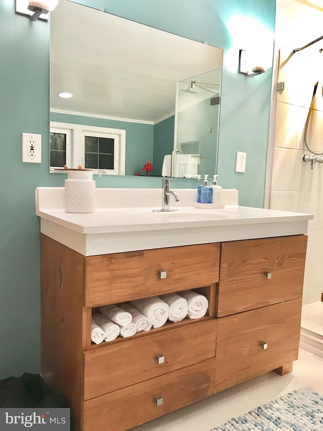 bathroom featuring vanity, a shower, and crown molding