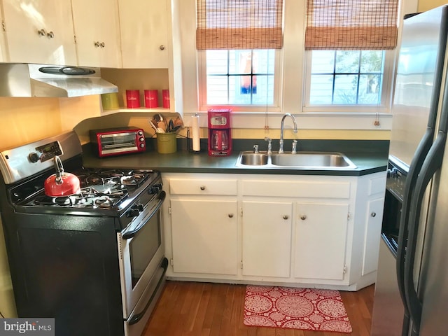 kitchen with wood-type flooring, stainless steel appliances, white cabinetry, and sink