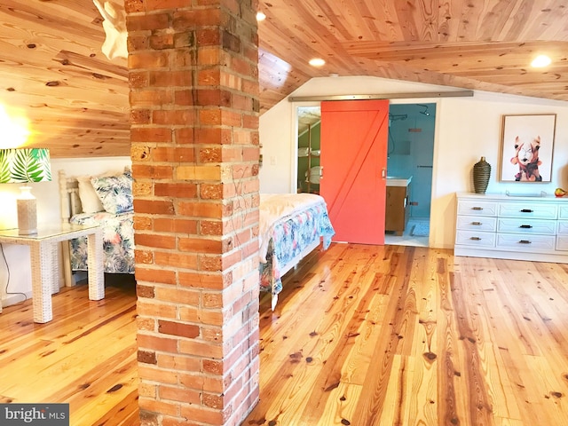 unfurnished bedroom with light wood-type flooring, a barn door, wooden ceiling, and lofted ceiling