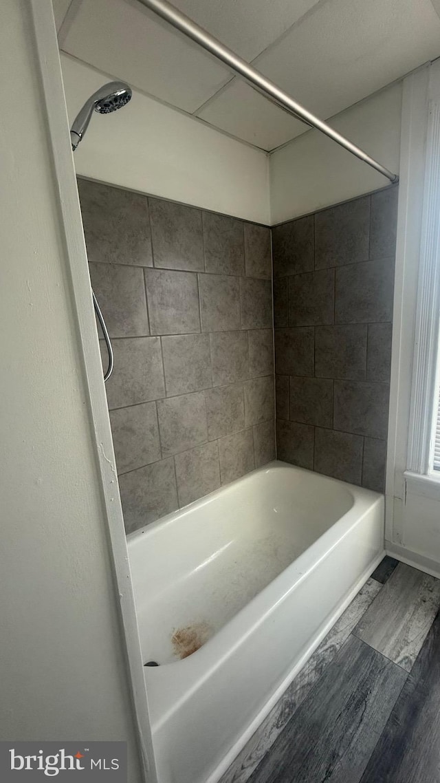 bathroom featuring tiled shower / bath combo and hardwood / wood-style flooring