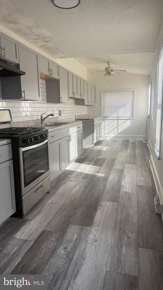 kitchen featuring sink, backsplash, dark hardwood / wood-style flooring, stainless steel range with gas cooktop, and gray cabinets