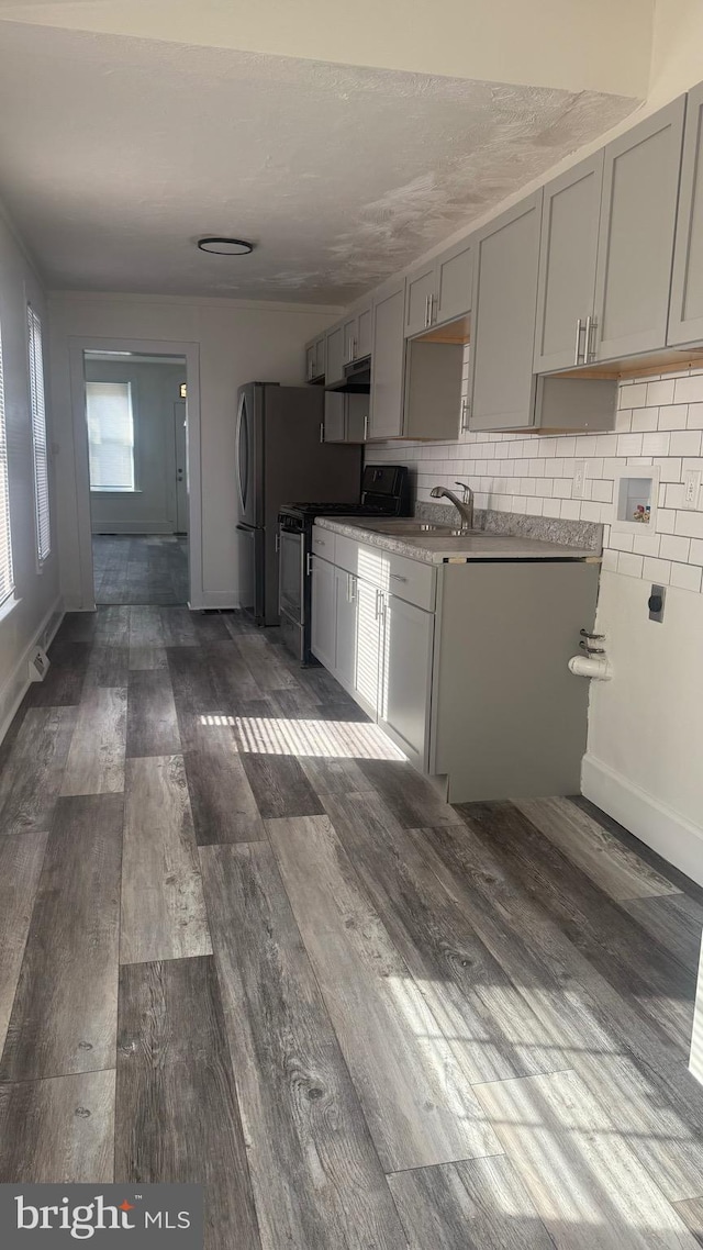 kitchen featuring gray cabinetry, tasteful backsplash, black range oven, and dark hardwood / wood-style floors