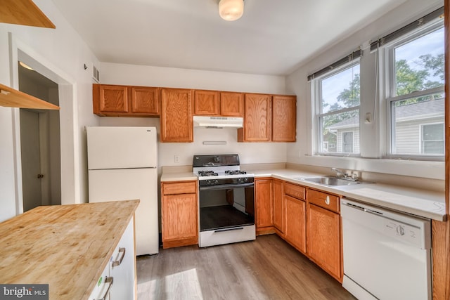 kitchen featuring white appliances, light hardwood / wood-style floors, sink, and butcher block counters