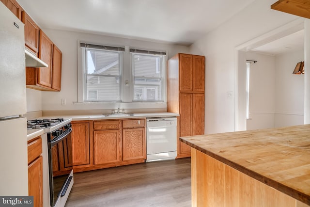 kitchen featuring white appliances, butcher block countertops, sink, and dark hardwood / wood-style floors